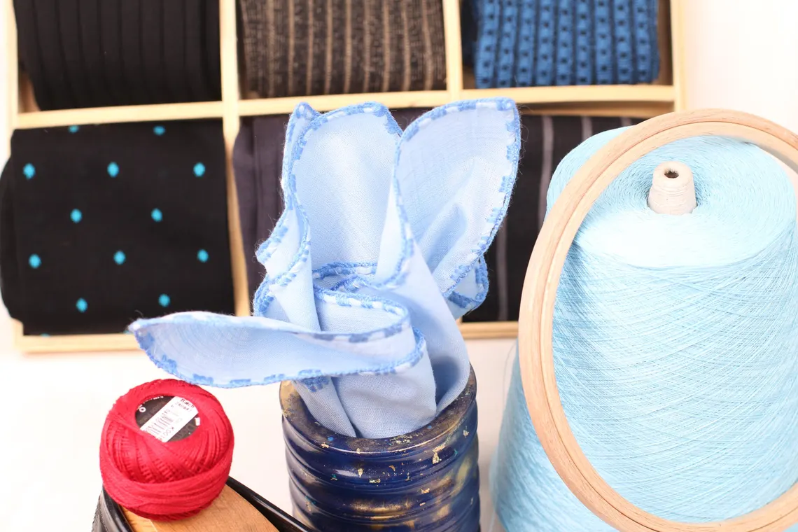 Classic men’s pocket square in blue linen, styled in a suit pocket.